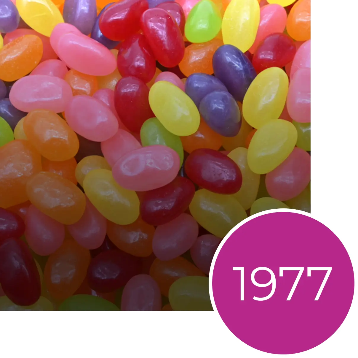 A collection of multi-colored jelly beans with a purple circle showing the number 1977 in the bottom right corner.